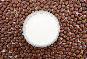 glass of milk on a background of chocolate balls. View from above. Cereal.