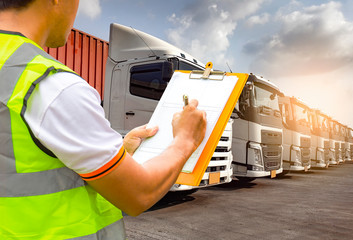 Worker holding clipboard to control and manage the loading of trucks. Road freight industry transport.