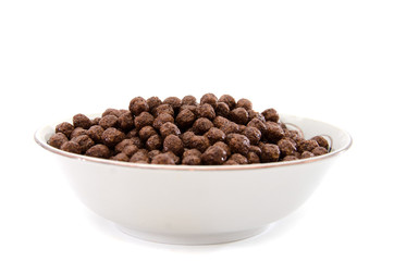 dry breakfast in a plate on a white background. Chocolate balls.