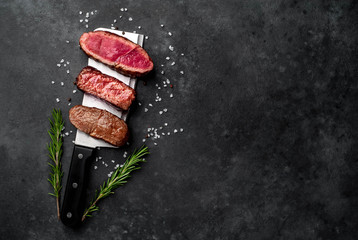 Three  pieces of meat grilled over a meat knife Three types of frying meat, rare, medium, well...