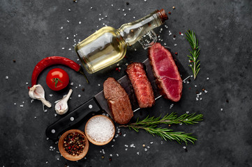 Three  pieces of meat grilled over a meat knife Three types of frying meat, rare, medium, well done. on stone background with copy space for your text