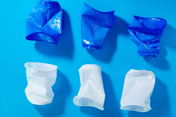 Naklejka premium disposable plastic cups on a blue background. the concept of abandoning plastic. the use of plastic