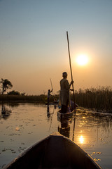 Traditionelle Boote (Mokoros) im Sonnenuntergang im Okavango Delta, Botswana