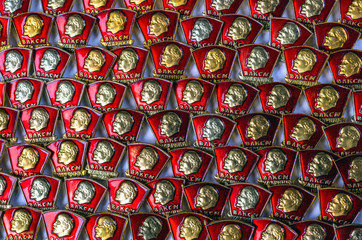 Kyiv, Ukraine - March 19, 2017. Vintage badges of members of the Komsomol - the silhouette of Lenin on the background of the red banner. Background from the Komsomol emblems of the USSR.