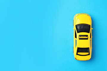 Yellow taxi car model on light blue background, top view. Space for text