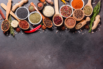 Spices and herbs over black stone background. Top view with free space for menu or recipes