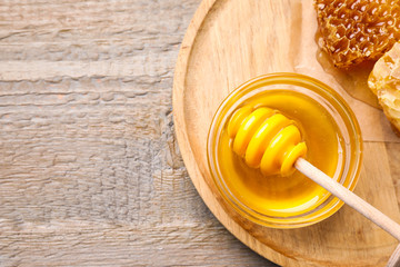 Tasty aromatic honey on wooden table, flat lay. Space for text