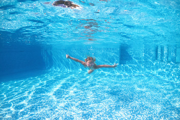 little girl dives into the water, summer vacations.