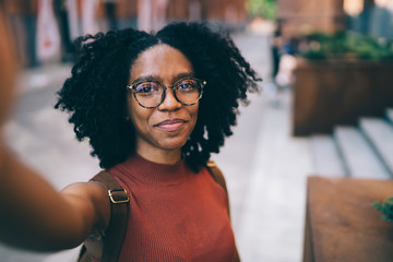 Young black woman smiling and taking selfie