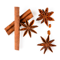 Cinnamon sticks and three anise star spice with seeds. Close up macro isolated on white background with light shadow. Top view, flat lay,