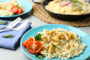 Delicious chicken risotto served on grey table