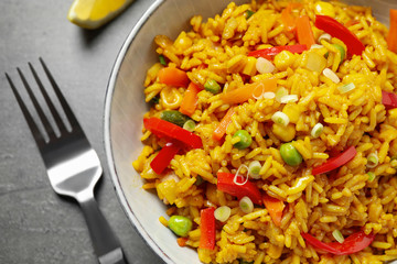 Delicious rice pilaf with vegetables on grey table, closeup