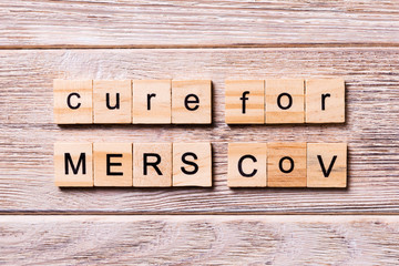 cure for MERS CoV word written on wood block. stop cure for MERS CoV text on wooden table for your desing, coronavirus concept top view