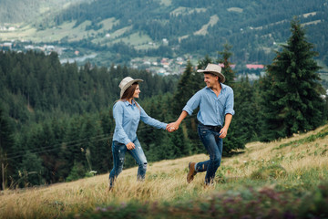 Obraz na płótnie Canvas Happy couple of hikers hiking holding hands joyful, cheerful and fresh. Young active multiracial couple in outdoor activity hike