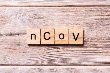 nCoV word written on wood block. nCoV text on wooden table for your desing, coronavirus concept top view