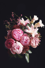 Beautiful bouquet of different flowers on black background. Floral card design with dark vintage effect
