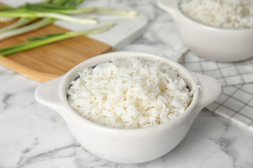 Bowl with tasty cooked rice on marble table, closeup