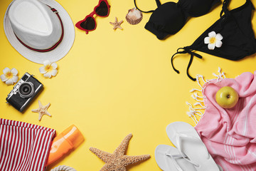 Frame made of beach objects on yellow background, flat lay. Space for text