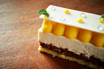 Yellow cream cake on wooden background 