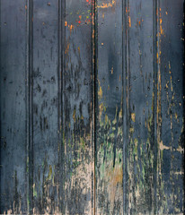 old worn wooden surface with vertical panels, rough texture with scratches and dark blue color in the background