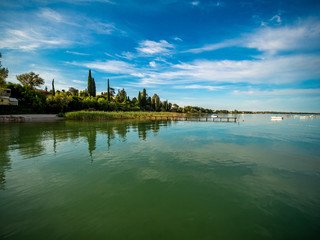 Fototapeta na wymiar Lago di Garda in northern Italy, family tourism boats, crystal clear water, summer holidays vacations