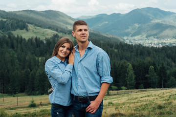 Fototapeta na wymiar Young couple in mountains smiling