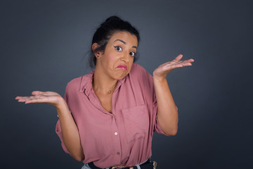 Maybe yes or no. Doubtful fashionable girl shrugs shoulders in bewilderment, tries to make decision...