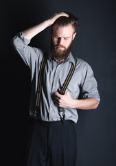 Young, handsome man with a beard posing on a black background in the studio.