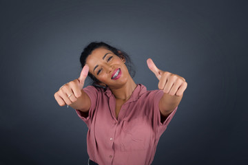 Young blonde woman over isolated background approving doing positive gesture with hand, thumbs up...