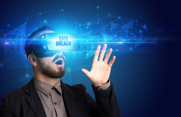 Businessman looking through Virtual Reality glasses with DATA BREACH inscription, cyber security concept