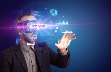 Businessman looking through Virtual Reality glasses with FORESIGHT inscription, new business concept