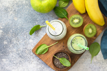Healthy dieting and nutrition. Vegetarian concept. Blended Green detox vegetable smoothies with organic ingredients on a stone concrete tabletop. Top view flat lay background. Copy space.