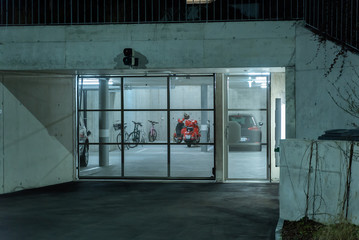 ZURICH, SWITZERLAND - JANUARY 14, 2020: Outdoor night view into garage through of metal net barrier...