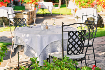Typical restaurant terrace with chairs and tables ready for a meal at the luxurious resort in Ascona on Lake Maggiore in Ticino canton of Switzerland.