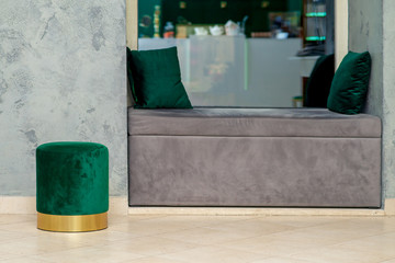 One soft green round ottoman next to soft grey sofa with two little pillows, mock up, interior.