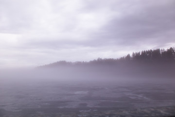 Zugefrorener Stausee in Nebel