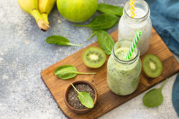 Healthy dieting and nutrition. Vegetarian concept. Blended Green detox vegetable smoothies with organic ingredients on a stone concrete tabletop. Copy space.