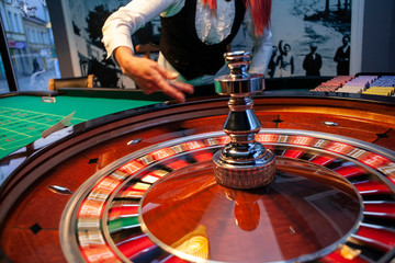 Spinning roulette wheel and croupier hand 