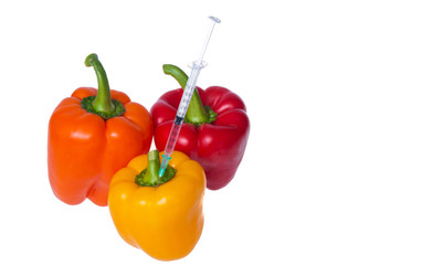 Genetically modified vegetables. GMO food concept. Syringes are stuck in vegetables with chemical additives. Injections into fruits and vegetables. Isolated on white background.