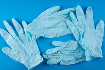 Several medical gloves on a blue background.