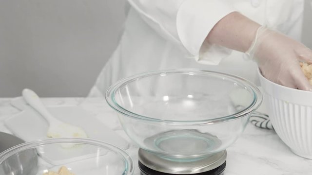 Step by step. Measuring cookie dought with a digital kitchen scale to bake red, white, and blue pinwheel sugar cookies.