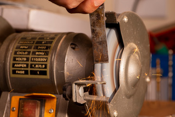 luthier using grinder to prepare metal part