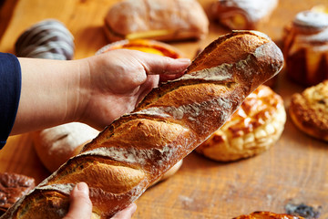 Baguette bread in hand at bakery 