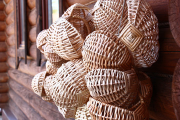 In the village on a wall of the wooden house many new wattled baskets weigh.