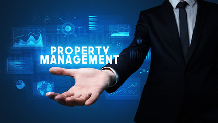 Hand of Businessman holding PROPERTY MANAGEMENT inscription, business success concept