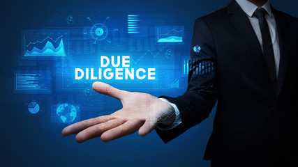 Hand of Businessman holding DUE DILIGENCE inscription, business success concept