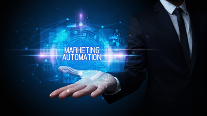 Man hand holding MARKETING AUTOMATION inscription, technology concept