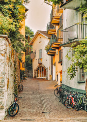 Cobblestoned Street with bicycles at romantic luxury resort in Ascona town on Lake Maggiore of Ticino canton in Switzerland. Outdoor expensive family travel in Swiss city in summer. Italian Holiday