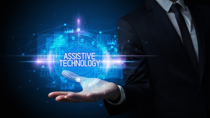 Man hand holding ASSISTIVE TECHNOLOGY inscription, technology concept