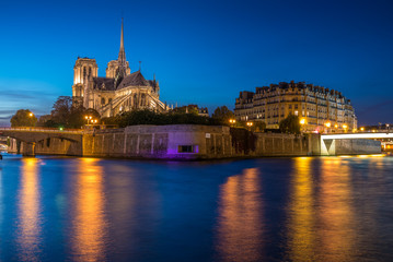 Obraz premium Church of Notre Dame de Paris in France before burning fire at sunset on river Seine reflecting lights